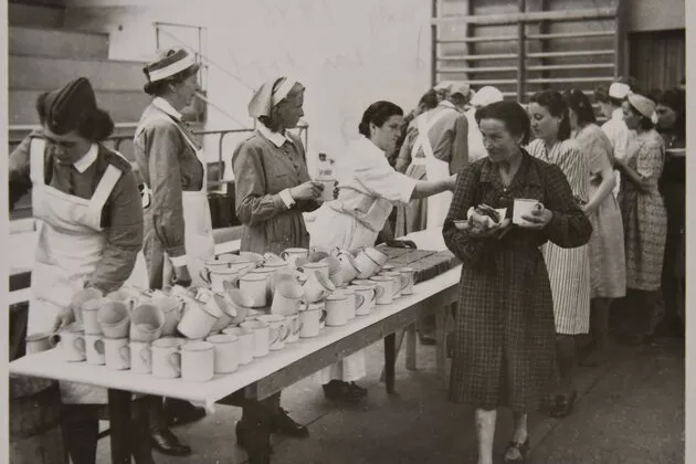 Bild på judiska kvinnor som blir serverade mat i Lunds sporthall, 1945